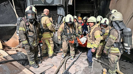 Fiel den Flammen zum Opfer: Mitglieder der Istanbuler Feuerwehr tragen am Dienstag die Leiche eines Mannes aus dem Gebäude des «Masquerade»-Nachtklubs, in dem zuvor ein Feuer ausgebrochen war. 