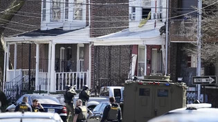 Polizisten umstellen das Haus in Trenton, in dem sich der mutmaßliche Täter mit seinen Geiseln verschanzt hat. Foto: Matt Rourke/AP/dpa