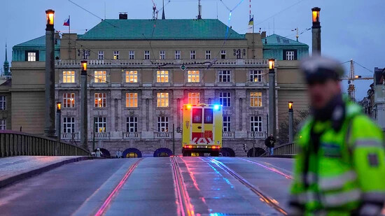 Ein Krankenwagen fährt in Richtung des Gebäudes der Philosophischen Fakultät der Karlsuniversität. An einer Hochschule in der Prager Innenstadt sollen Schüsse gefallen sein. Foto: Petr David Josek/AP