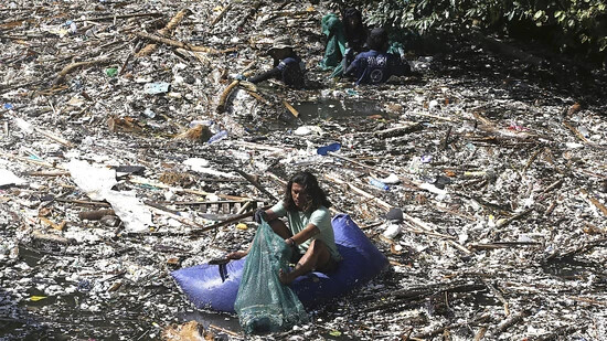 Ein Freiwilliger sammelt in Pecatu auf Bali Müll aus einem Fluss. Während der Monsunzeit sind einige Flüsse mit Plastikmüll und Unrat übersät. Foto: Firdia Lisnawati/AP