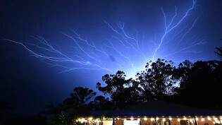 An electrical storm is seen at Reedy Creek on the Gold Coast Monday, December 25, 2023. A woman has died after being struck by a tree after winds of 100 kph lashed the Gold Coast, bringing down trees, powerlines. (AAP Image/Dave Hunt) NO ARCHIVING