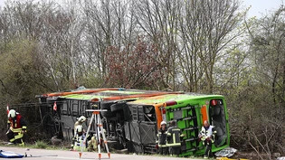 Ein Reisebus liegt zur Seite gekippt an der Unfallstelle auf der A9. Foto: Jan Woitas/dpa