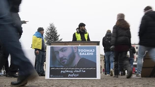 ARCHIV - Ein großes Plakat steht bei einer Protestaktion gegen Irans Staatsführung auf dem Pariser Platz. Es zeigt den iranischen Rapper Toomaj Salehi. Foto: Paul Zinken/dpa